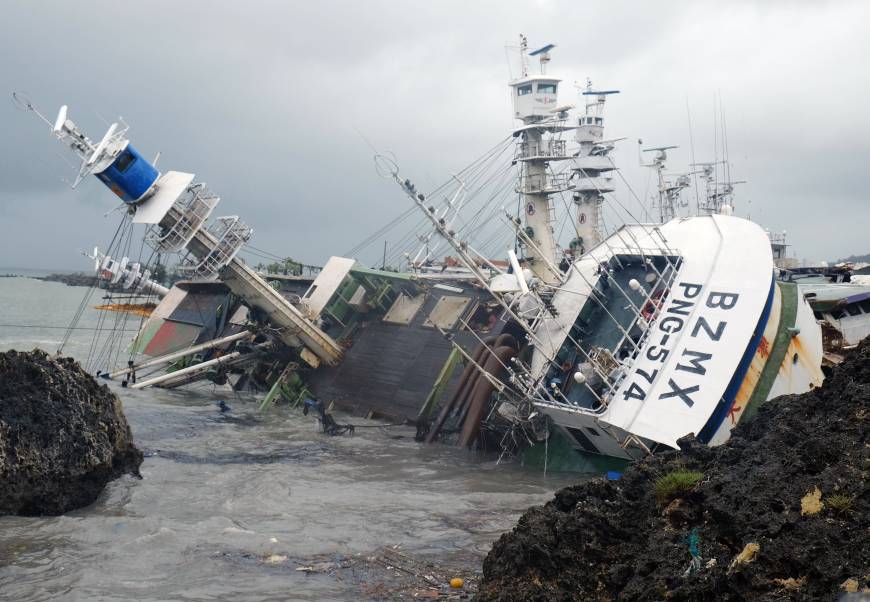 A fishing boat that overturned during Typhoon Meranti lies in the harbor in the community of Sizihwan in the Taiwanese municipality of Kaohsiung on Thursday. | AFP-JIJI